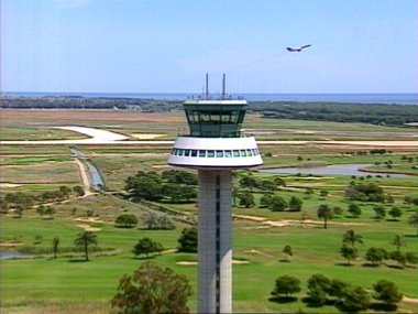 Imatge a&egrave;ria de la nova torre de control ol&iacute;mpica, el Reial Club de Golf i un avi&oacute; enlairant-se per la transversal